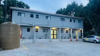 a white building with a car parked in a parking lot at 373 Guest House in Pretoria