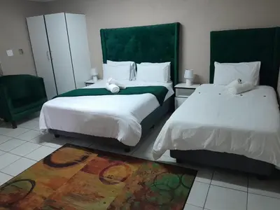 a bedroom with two beds and a rug at 373 Guest House in Pretoria