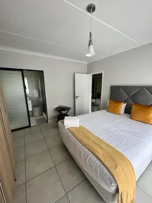 a bedroom with a large bed with orange pillows at The lagoon retreat in Avondzon