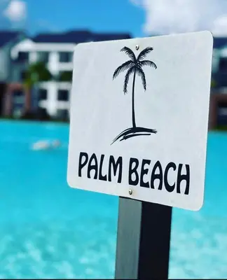 a sign with a palm tree on a beach at The lagoon retreat in Avondzon