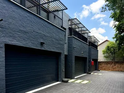 two garage doors on the side of a brick building at 41 on 20th in Pretoria