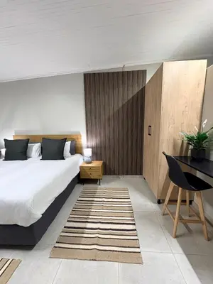 a bedroom with a large bed and a desk at Green Haven Waitara in Tzaneen