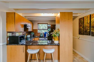 a kitchen with a counter and stools in a room at Urban Tuscany Apartment in Sandton