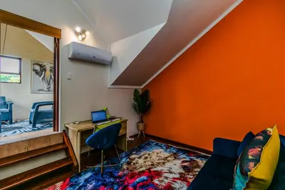 a living room with an orange wall at Urban Tuscany Apartment in Sandton