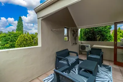 a patio with two chairs and a window at Urban Tuscany Apartment in Sandton