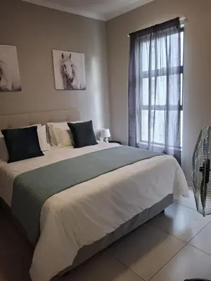 a bedroom with a large bed with a window at Oak and Olive Retreat Midrand in Midrand