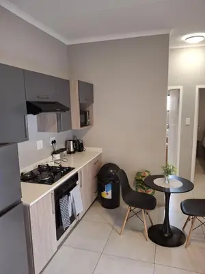 a kitchen with a stove and a table and chairs at Oak and Olive Retreat Midrand in Midrand
