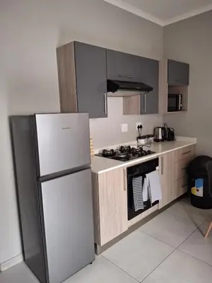 a kitchen with a refrigerator and a stove at Oak and Olive Retreat Midrand in Midrand