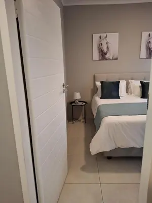 a bedroom with two beds and a door to a room at Oak and Olive Retreat Midrand in Midrand