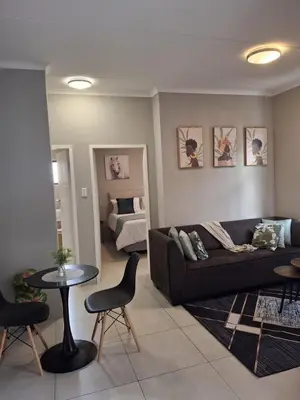 a living room with a couch and a table and a bed at Oak and Olive Retreat Midrand in Midrand