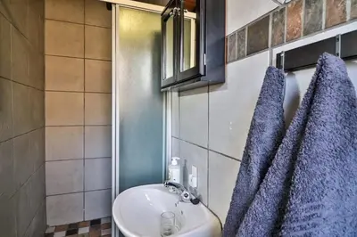 a bathroom with a sink and a blue towel at Inyathi in Marloth Park
