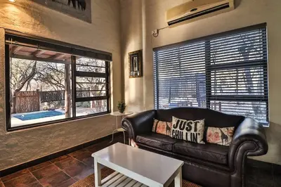a living room with a leather couch and a table at Inyathi in Marloth Park