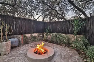 a fire pit in a backyard with a fence at Inyathi in Marloth Park