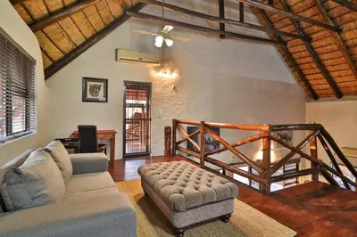 a living room with a couch and a chair at Inyathi in Marloth Park