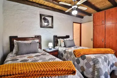 a bedroom with two beds and a ceiling at Inyathi in Marloth Park