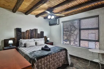 a bedroom with a large bed and a large window at Inyathi in Marloth Park