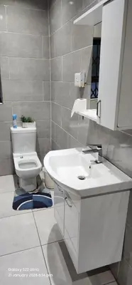 a bathroom with a white sink and a toilet at Thohoyandou P house rooms in Thohoyandou
