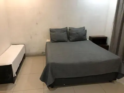 a bedroom with a bed with gray sheets and pillows at Thohoyandou P house rooms in Thohoyandou