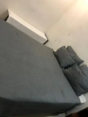 a bed with four pillows on top of it at Thohoyandou P house rooms in Thohoyandou