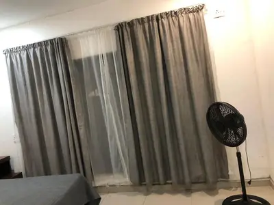 a bedroom with a window with curtains and a fan at Thohoyandou P house rooms in Thohoyandou