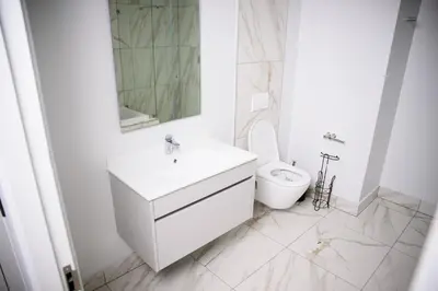 a white bathroom with a sink and a toilet at SoftStay Ellipse Luxury Apartment in Midrand