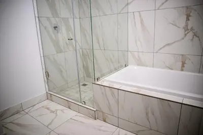 a bathroom with a shower and a bath tub at SoftStay Ellipse Luxury Apartment in Midrand