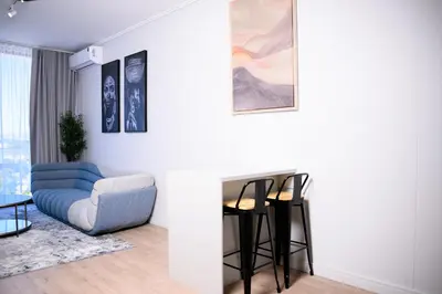 a living room with a blue couch and a chair at SoftStay Ellipse Luxury Apartment in Midrand