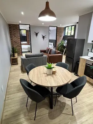 a living room with a table and chairs at 101 Brooklyn Stylish Apartment in Pretoria