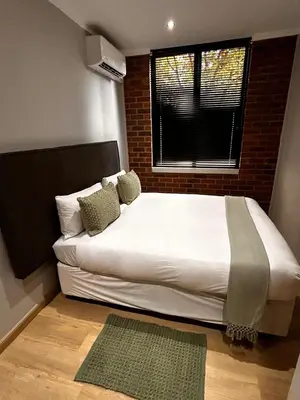 a bedroom with a large white bed with a window at 101 Brooklyn Stylish Apartment in Pretoria