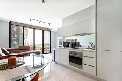 a kitchen and living room with a glass table at AlimamaSpaces Moskit's Newton Place in Midrand