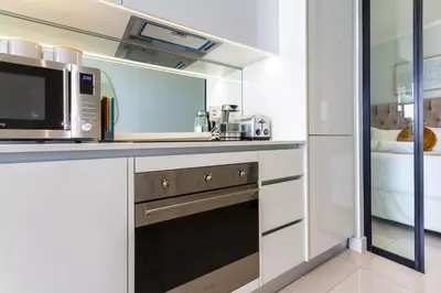a kitchen with a microwave oven and a sink at AlimamaSpaces Moskit's Newton Place in Midrand