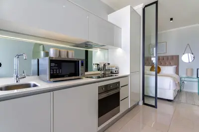 a kitchen with a sink and a microwave at AlimamaSpaces Moskit's Newton Place in Midrand