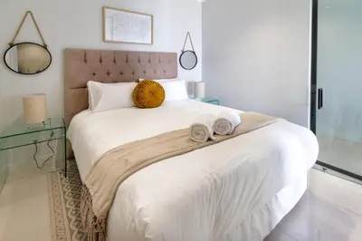 a bedroom with a large bed with towels on it at AlimamaSpaces Moskit's Newton Place in Midrand