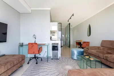 a living room with a couch and a table at AlimamaSpaces Moskit's Newton Place in Midrand