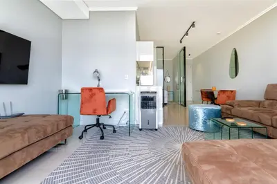 a living room with a couch and a table at AlimamaSpaces Moskit's Newton Place in Midrand