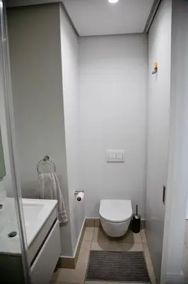 a bathroom with a white toilet and a sink at Ad Astra Studio Apartment - Waterfall in Midrand
