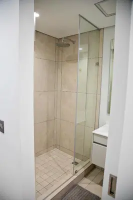 a shower with a glass door in a bathroom at Ad Astra Studio Apartment - Waterfall in Midrand