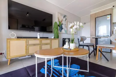 a kitchen and living room with a table and chairs at AlimamaSpaces Mikes Munyaka in Midrand