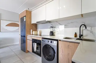 a kitchen with a washing machine and a sink at AlimamaSpaces Mikes Munyaka in Midrand
