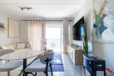 a living room with a table and a tv at AlimamaSpaces Mikes Munyaka in Midrand