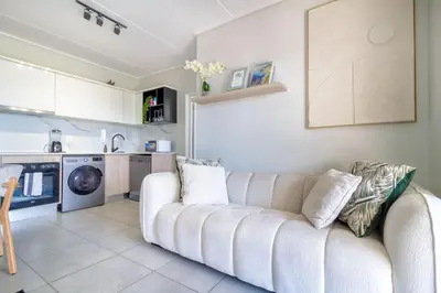 a living room with a couch and a kitchen at AlimamaSpaces Mikes Munyaka in Midrand