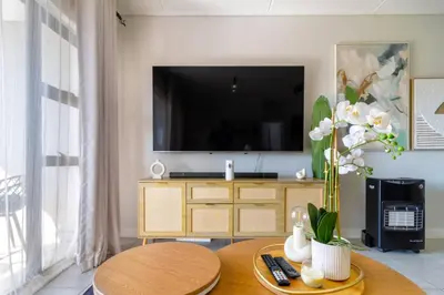 a living room with a tv and a table at AlimamaSpaces Mikes Munyaka in Midrand