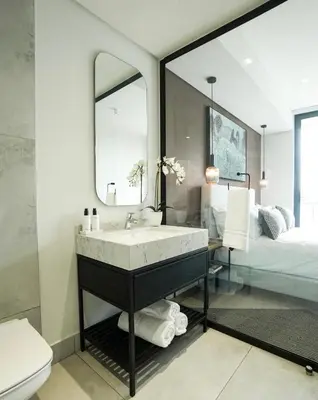 a bathroom with a sink and a mirror and a bed at Serenity Getaway in Midrand