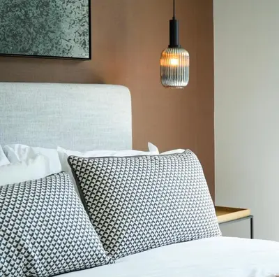a bedroom with a bed with a pillow and a lamp at Serenity Getaway in Midrand