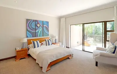 a bedroom with a bed and a couch and a chair at Ubuntu A home away from home in Midrand