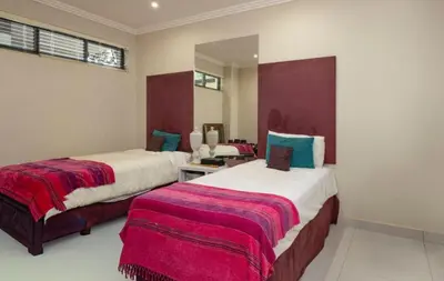 a bedroom with two beds with red and white blankets at Ubuntu A home away from home in Midrand