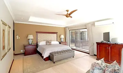a bedroom with a bed and a ceiling fan at Ubuntu A home away from home in Midrand