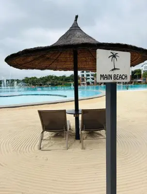 a beach with two chairs and an umbrella at 1 Bedroom Apartment at The Blyde, Pretoria in Pretoria