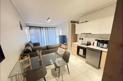 a kitchen and living room with a couch and a table at 1 Bedroom Apartment at The Blyde, Pretoria in Pretoria