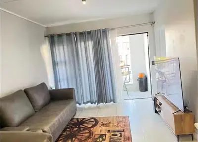 a living room with a couch and a large window at 1 Bedroom Apartment at The Blyde, Pretoria in Pretoria
